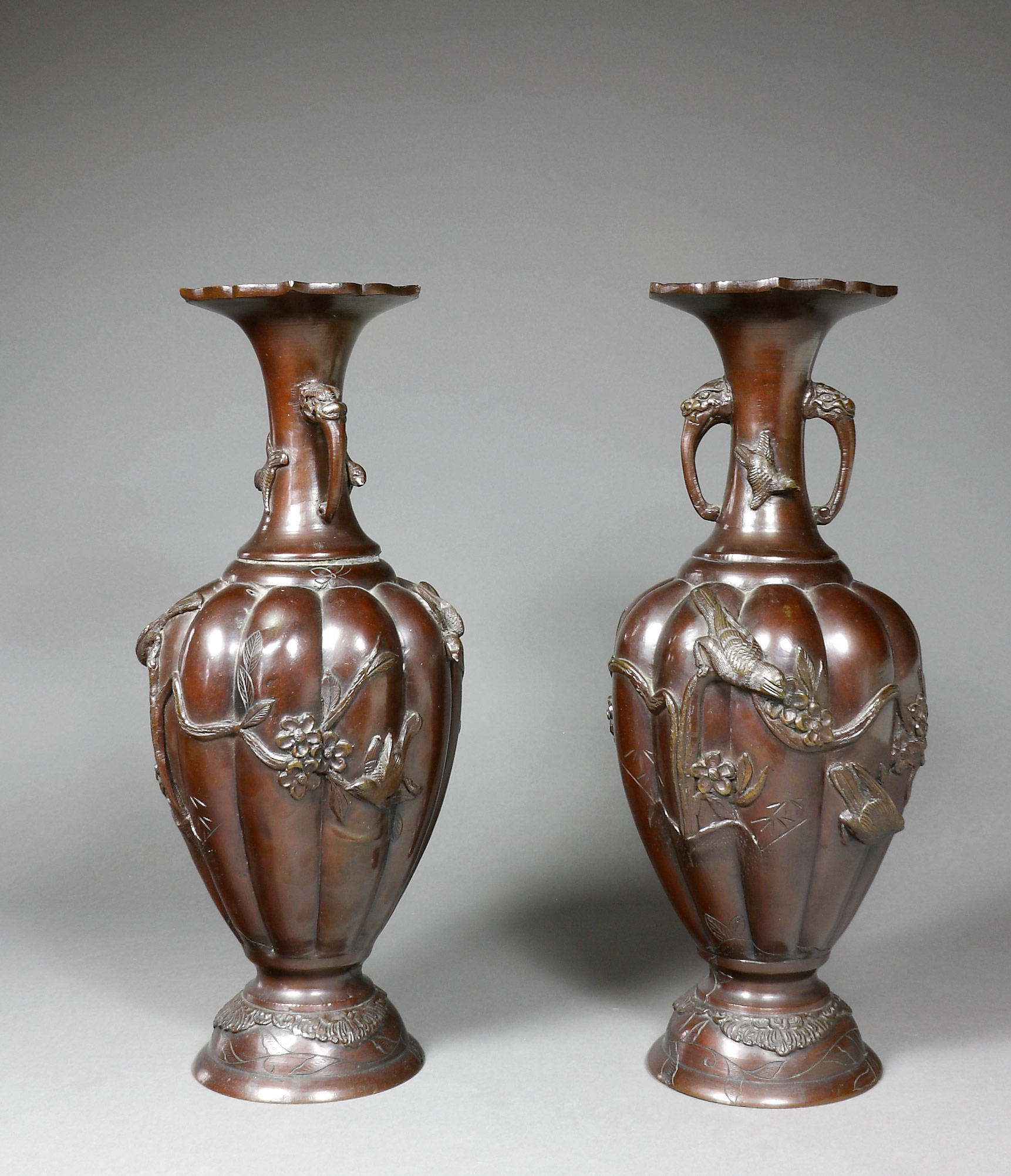 Auktionshaus Quentin Berlin  Asiatika Japan  Vasen  Bronze  Meiji  ein Paar Balusterform mit godronierter Wandung und erhabenem Reliefdekor von Vögeln und Blumen. Am eingezogenen Hals zwe