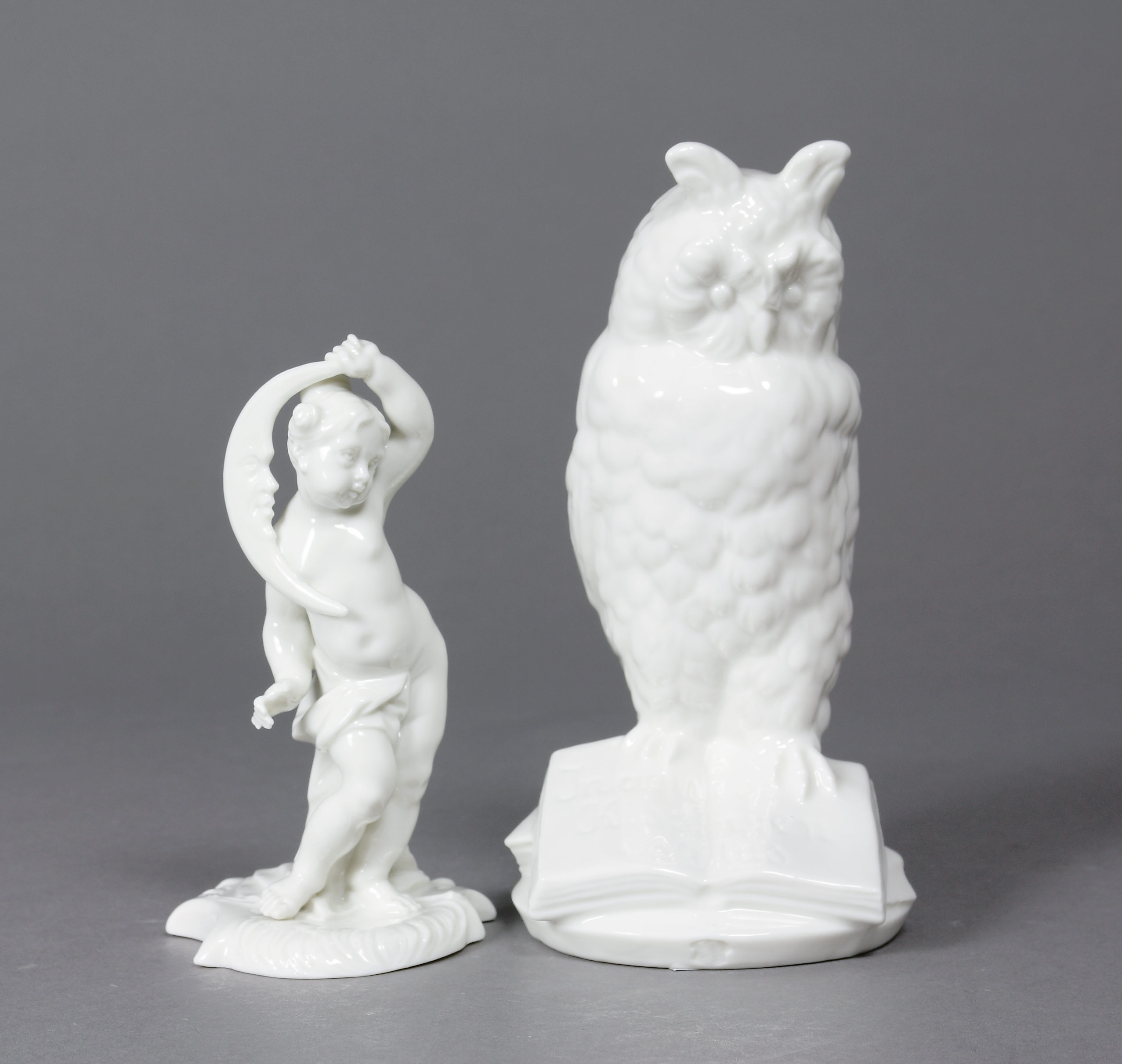 Auktionshaus Quentin Berlin  Skulptur Figuren  Nymphenburg  20. Jh.  zwei StÃ¼ck Eule auf Buch (H.: 15 cm) und Putto mit Halbmond (H.: 11 cm). GrÃ¼ne Stempelmarke und Rautenschildpress