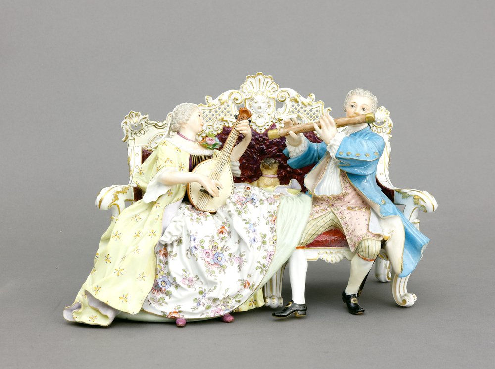 Auktionshaus Quentin Berlin  Porzellan / Fayence Figurengruppe  Meissen  1860 - 1923  Galante Sofagruppe mit Mops. Entwurf J. J. Kändler